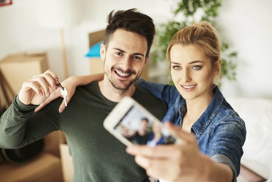 Haus-Paar-Umzug-Serie-13-10 Paar macht Selfie mit Hausschlüssel.